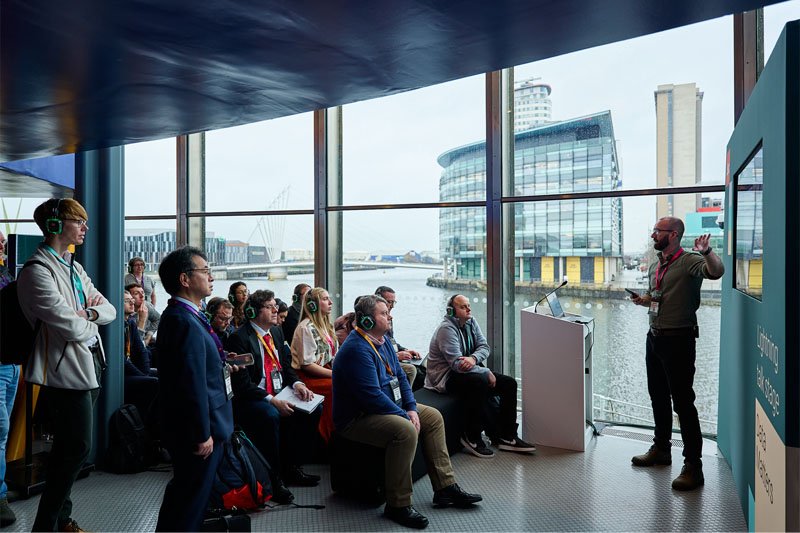 Delegates wearing branded headphones at a lightning talk at Data Matters 2025.