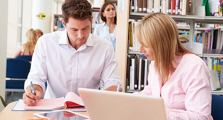 A man and woman working in a library.