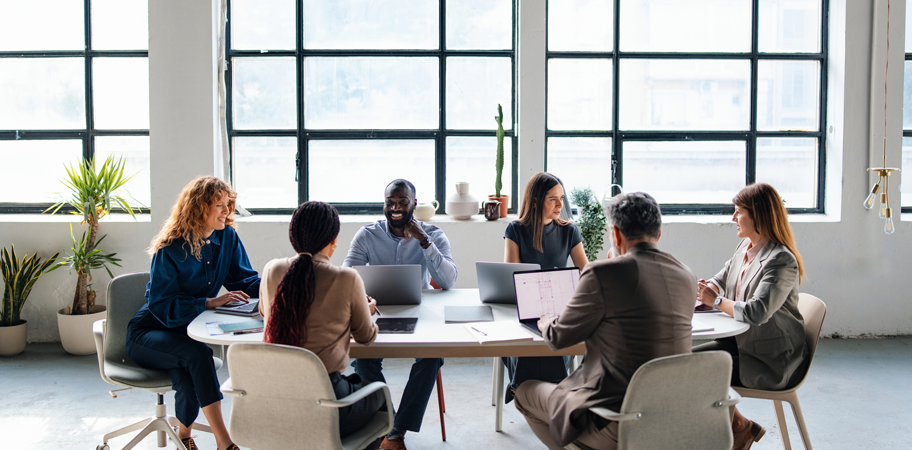 Business Team Engaged in a Collaborative Meeting at a Modern Office - stock photo Team members collaborating during a meeting in a bright, modern office setting with natural light.