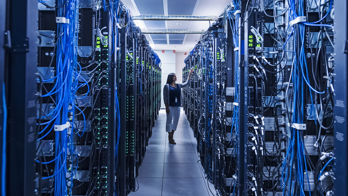 Woman standing in aisle of server room