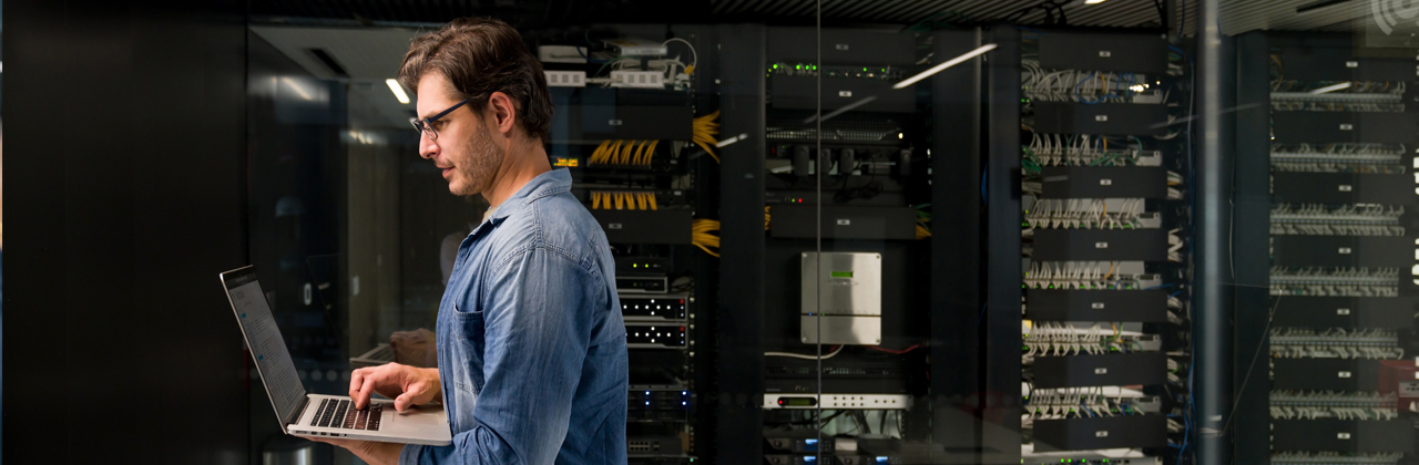 IT technician fixing a problem on a network server at an office building â technology concepts