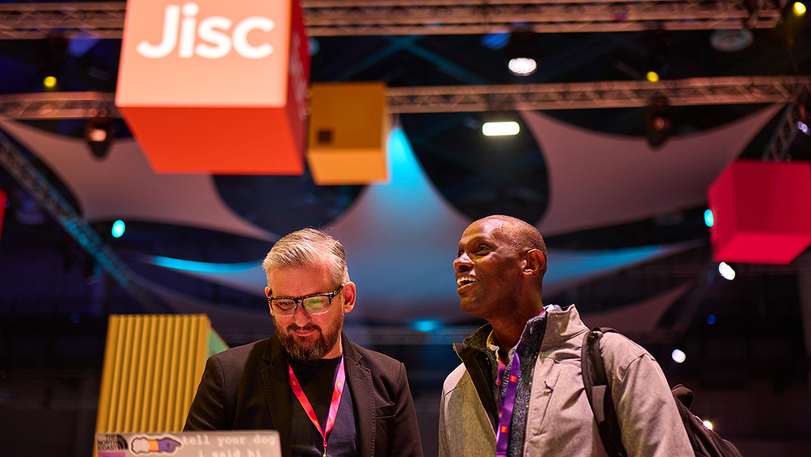 Two delegates chatting at a Jisc event.