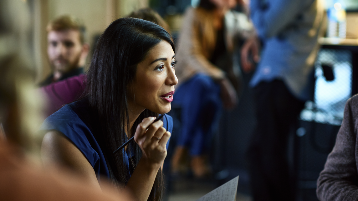 A professional woman talks with others in a relaxed environment.