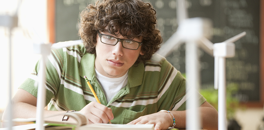 A male student studying from a book.