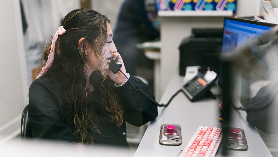 A female receptionist talking on the phone.