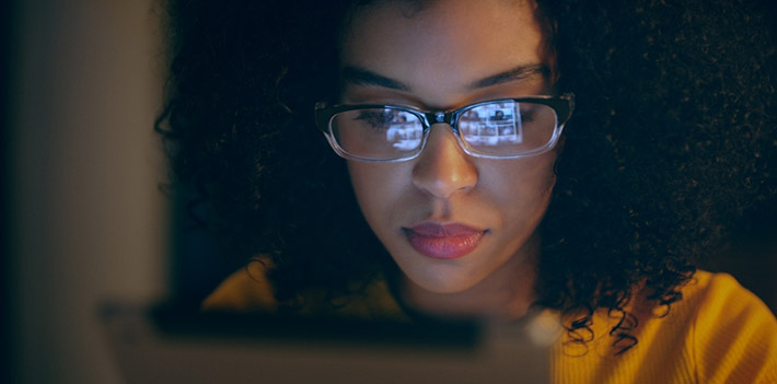 Female IT technician studying a laptop screen.