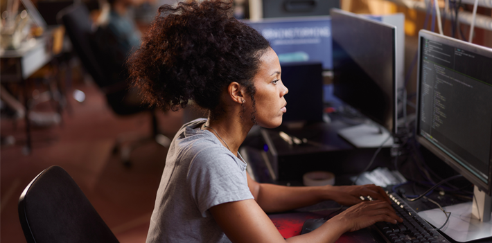 Female programmer working on PC in robotics lab