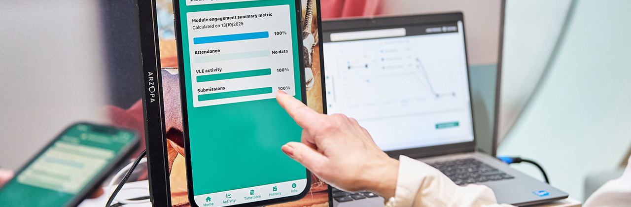 A female delegate pointing at a learning analytics app on a screen.