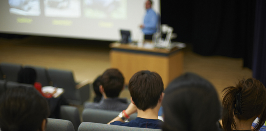 Students watching a lecturer in a lecture theatre.