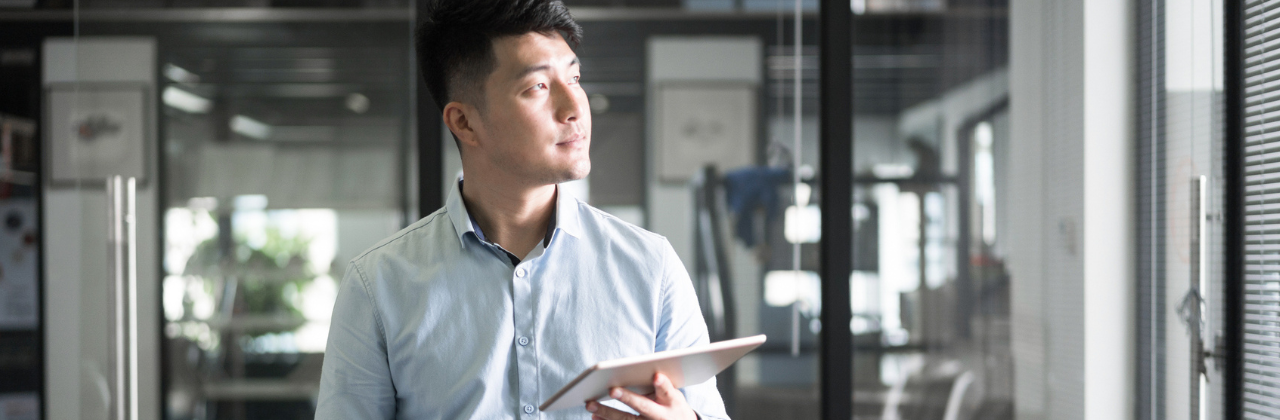 Young man uses digital tablet in modern office.
