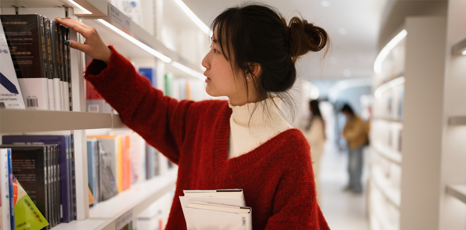 Woman browsing books in library.