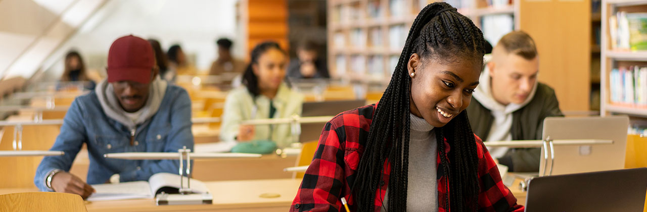 Young student is writing in the library