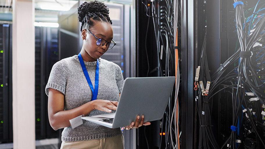 A female technician standing with a laptop.
