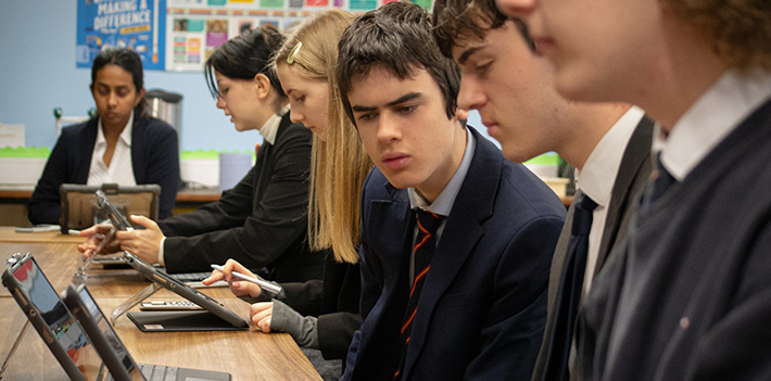 School pupils working on laptops in a classroom.