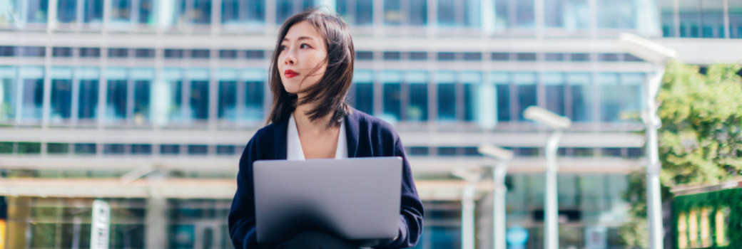 woman on laptop outside building